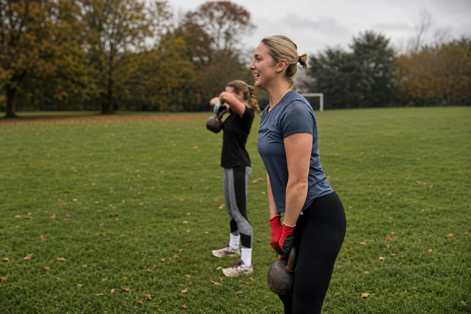 Members holding a group squat during an outdoor fitness class in Beacon Park, Lichfield